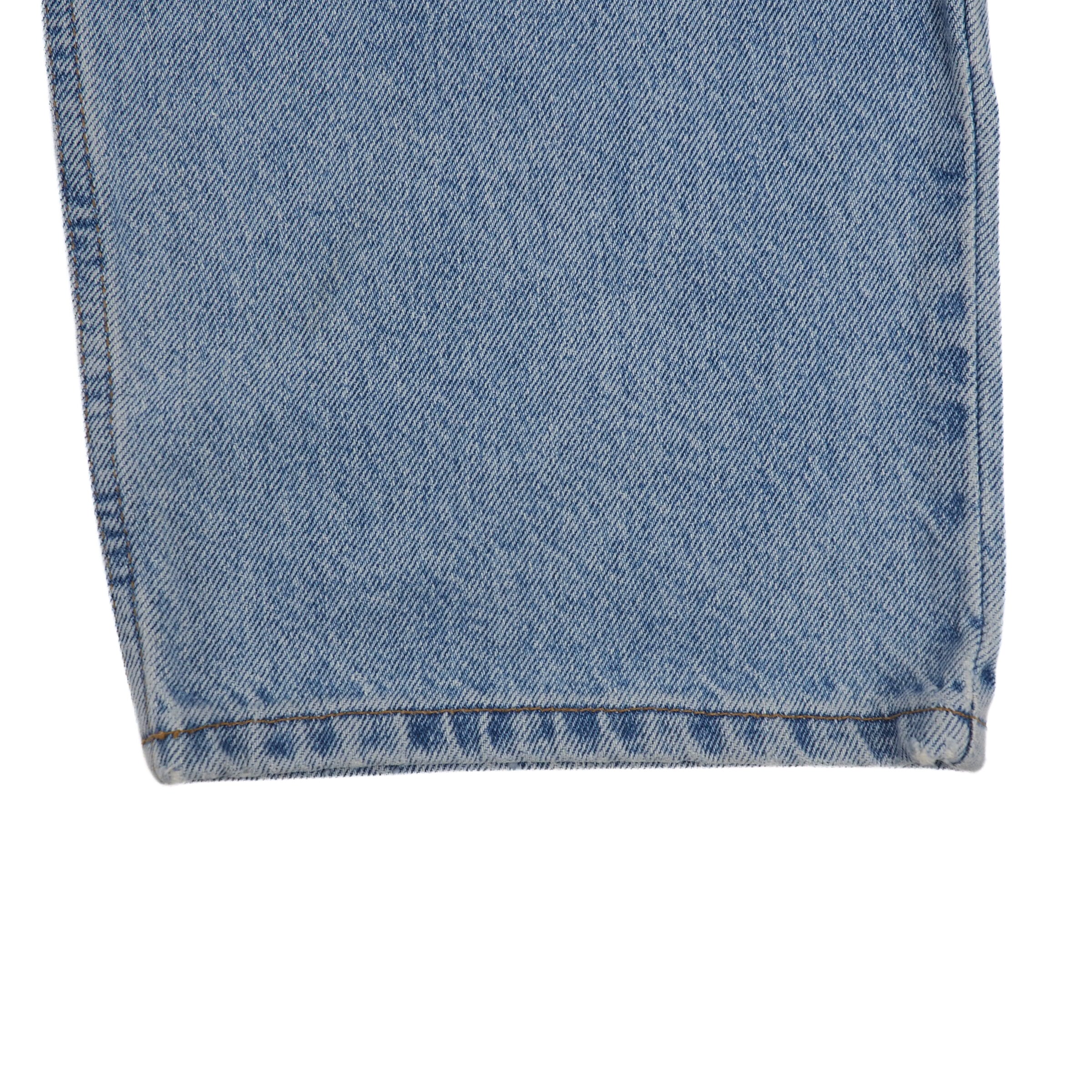 Close-up of blue denim jean pant ankle cuff on a white background