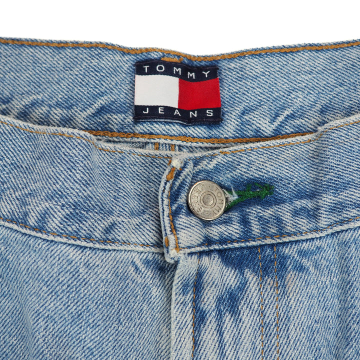 Close-up of a Tommy Jeans label on inside waistband of a pair of blue denim jeans.