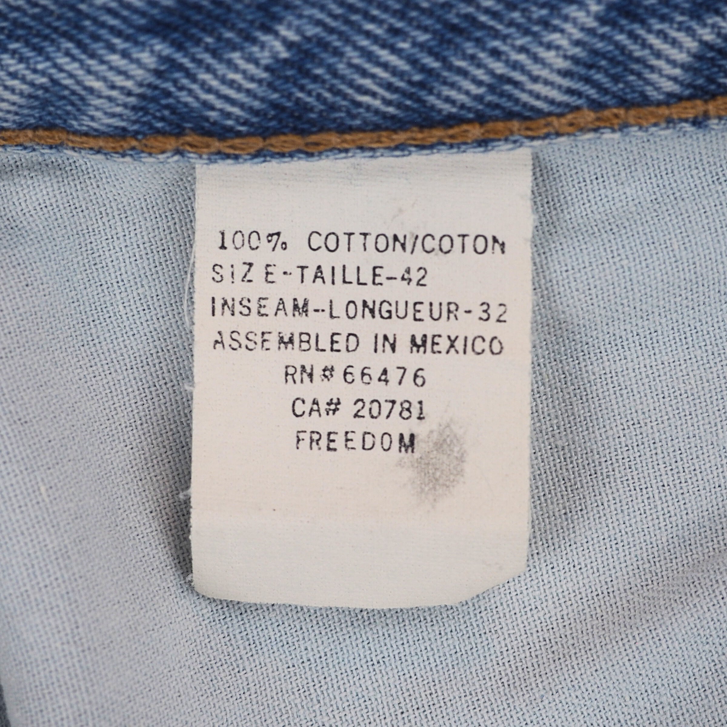 White fabric care tag with black text on a denim background