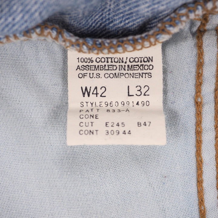 White clothing care label on denim fabric with black text and numbers