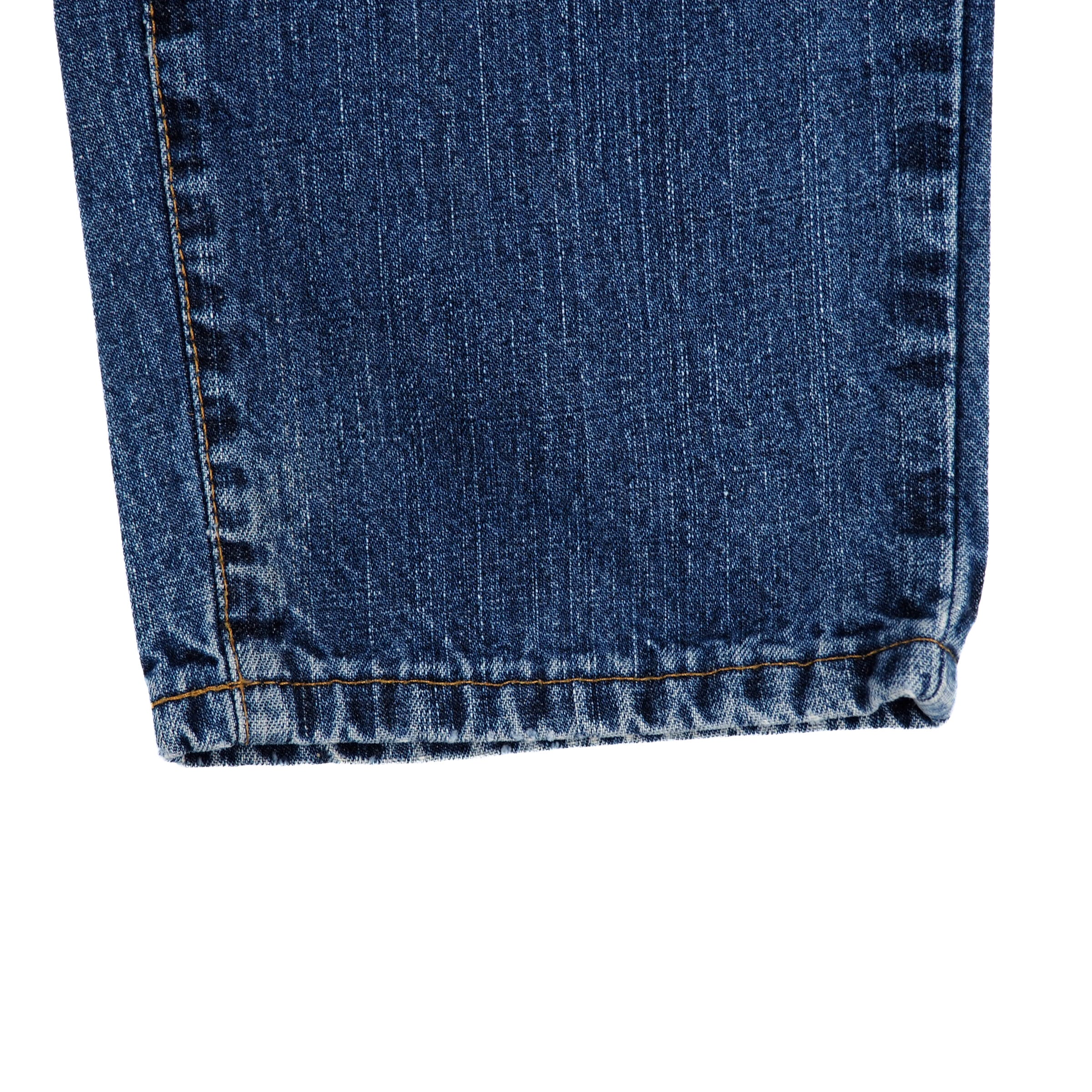 Close-up of blue denim jean pant leg cuff on a white background