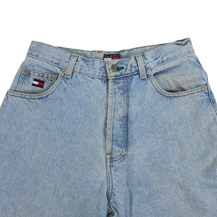 Light blue denim jeans with Tommy Hilfiger brand logos on a white background