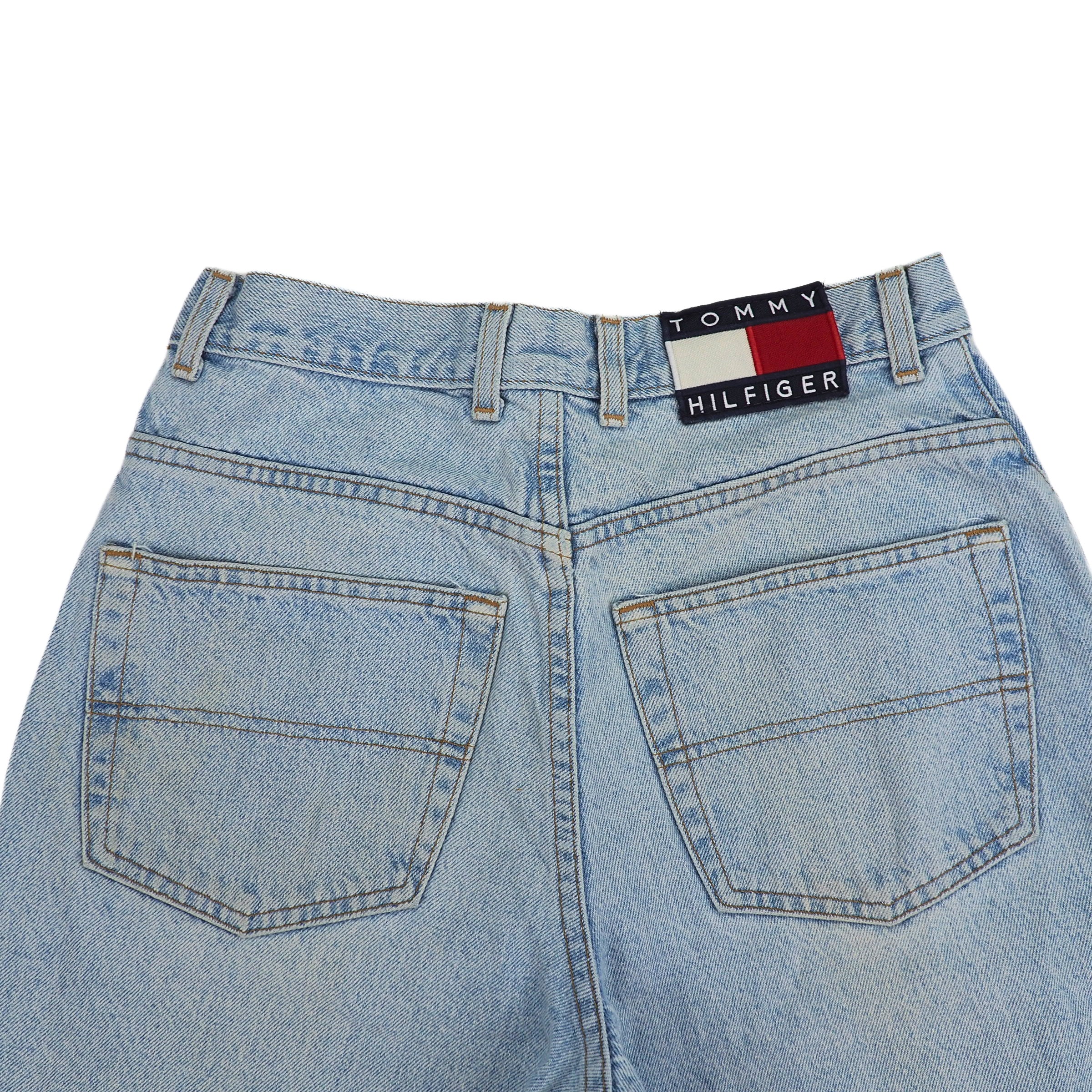 Back view of light blue jeans seat area with Tommy Hilfiger label on a white background