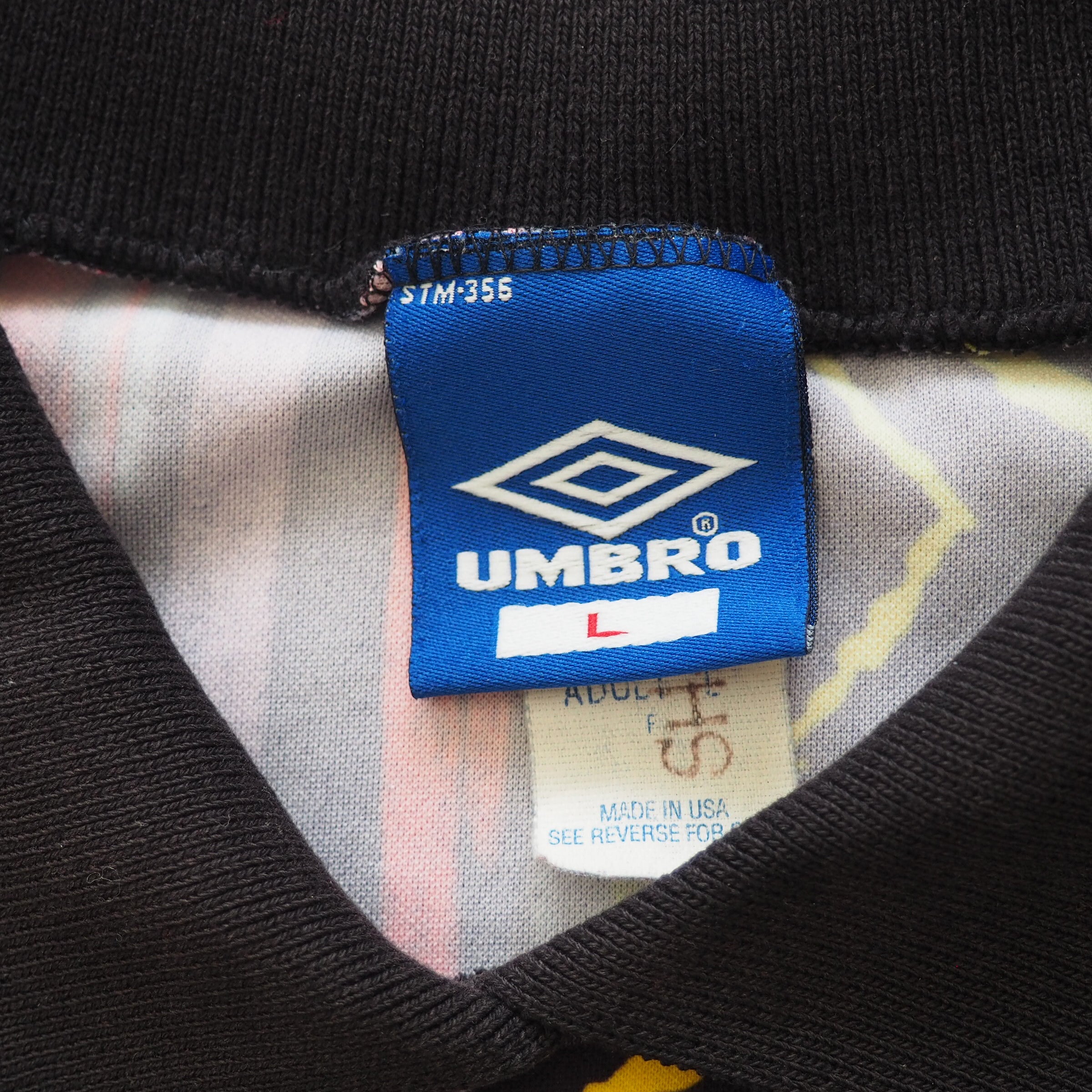 Close-up of a vintage Umbro tag on a garment inside collar.