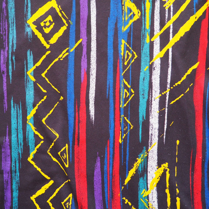 Close-up detail of a colorful abstract pattern with geometric shapes on a black background featured on a vintage umbro soccer jersey