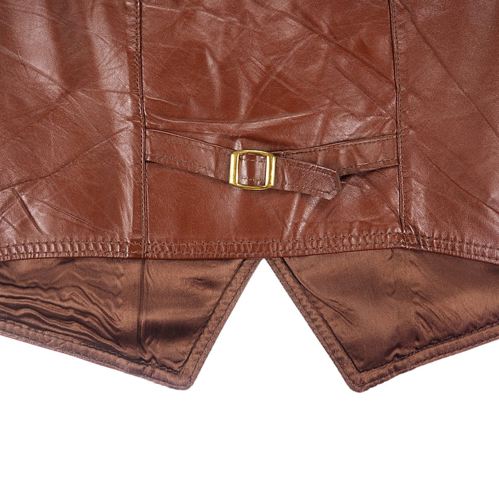 Close up of the back hem, buckle, strap and stitching of a brow leather garment.