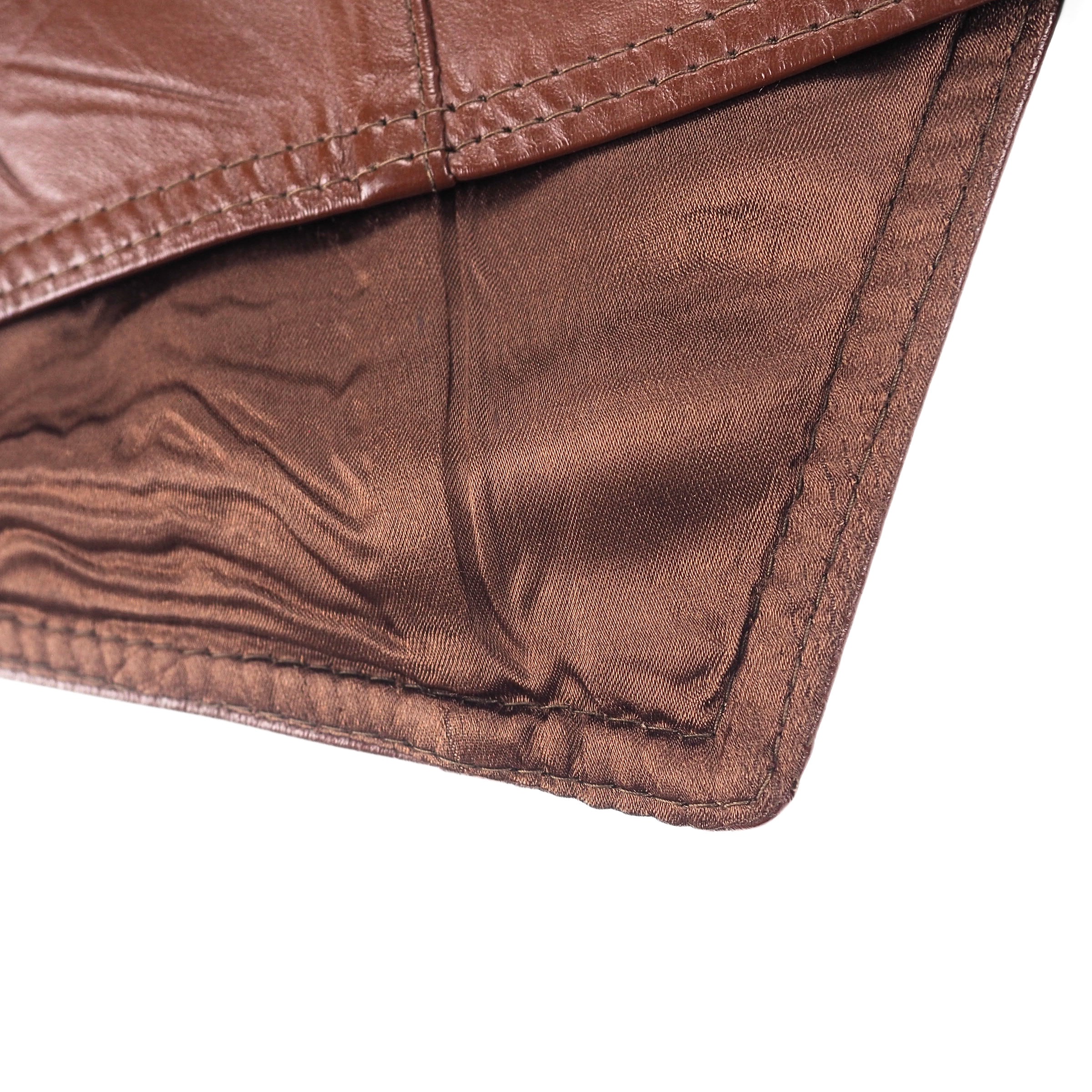 Close up of the satin inner lining of a brown leather waistcoat.