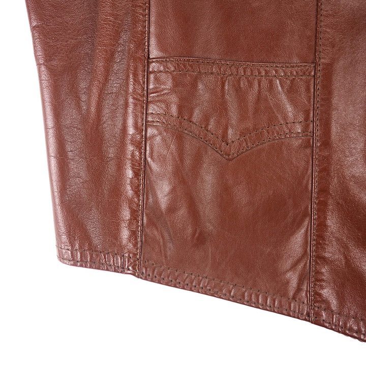 Close up of the pocket area of a brown leather vest jacket.