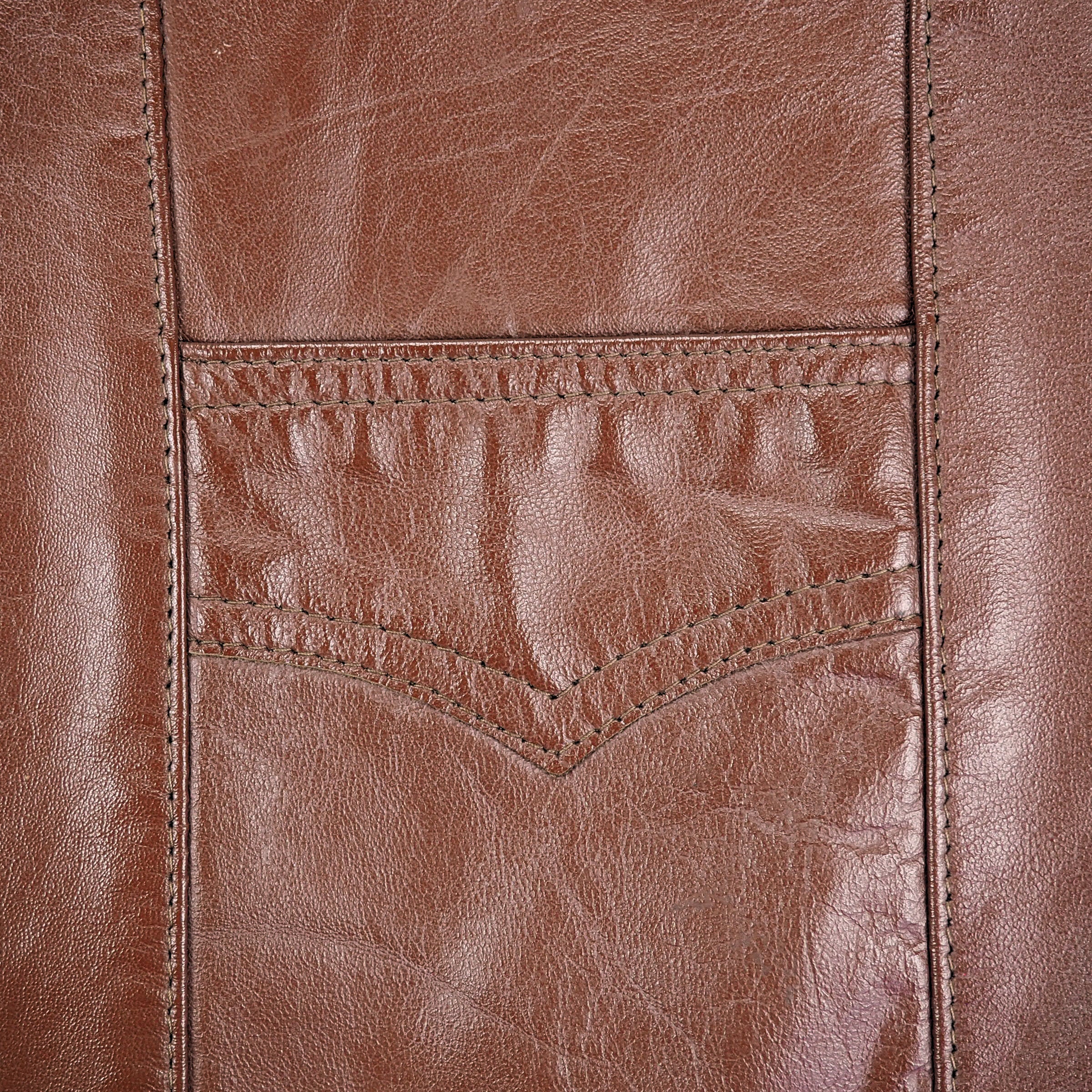 Close up of the pocket and stitching of a brown leather vest