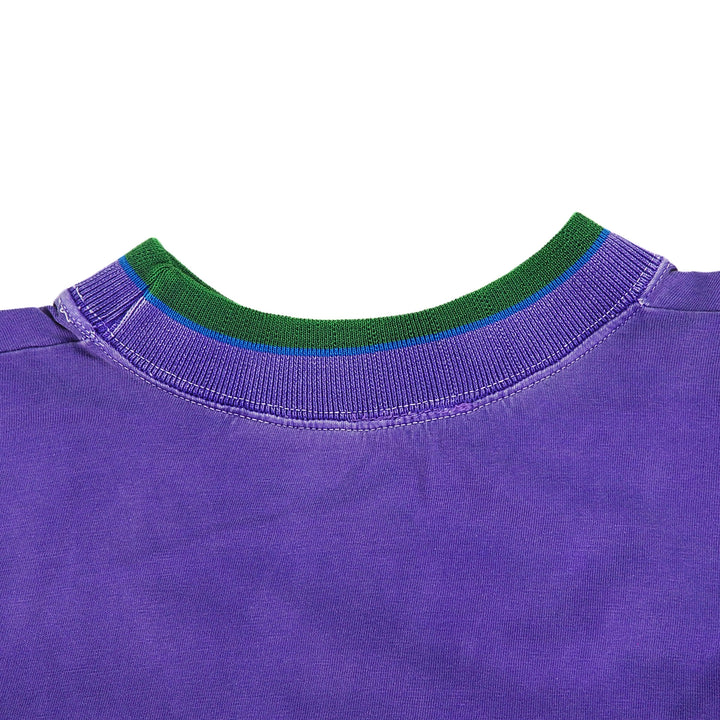 Close-up of a the back collar of a purple t-shirt with green trim on a white background