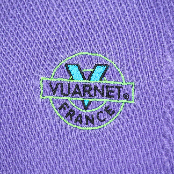 Close up of an Embroiderede 'Vuarnet France' logo on a purple t-shirt