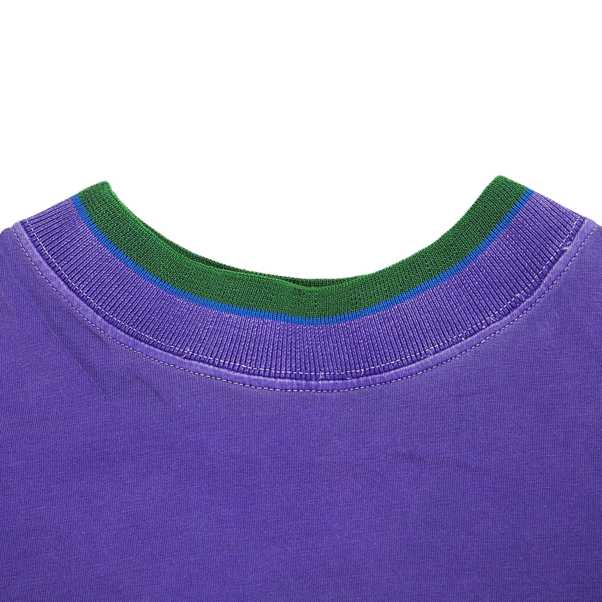 Close-up of a purple t-shirt with green ribbed collar on a white background
