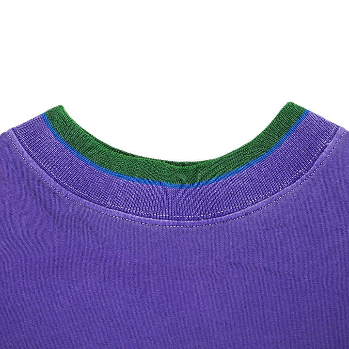 Close-up of a purple t-shirt with green ribbed collar on a white background