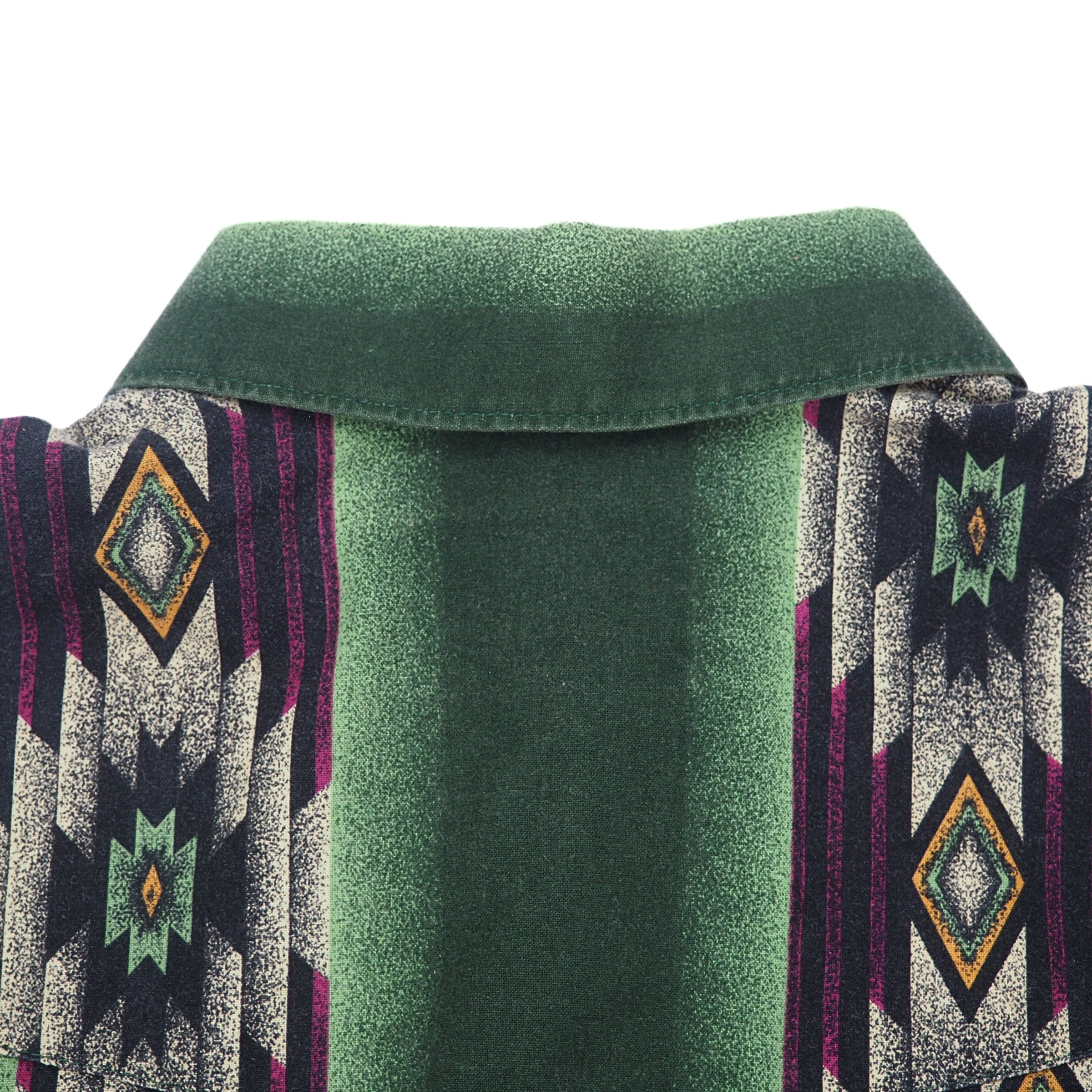 Close up of the back collar of a shirt with geometric pattern in green, purple, orange and cream.