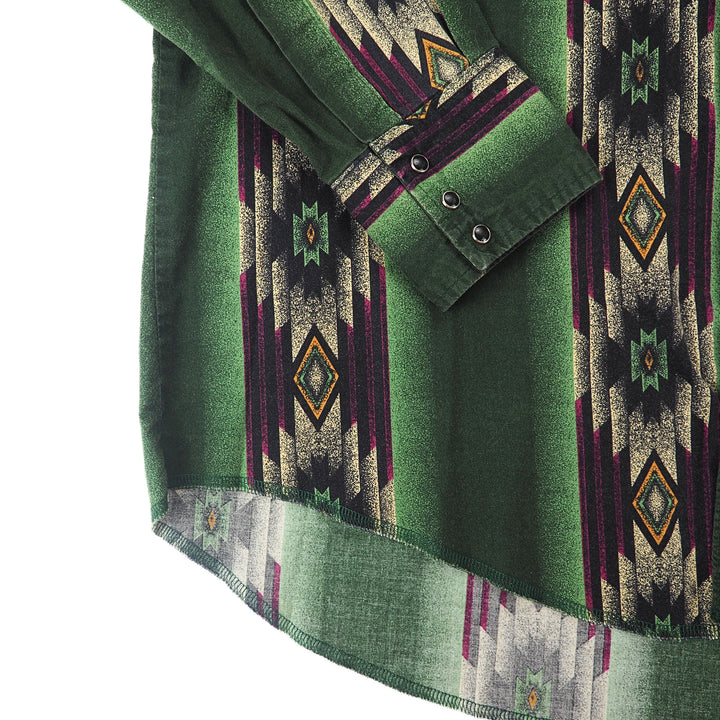 Close up of the cuff and onyx pearl snap buttons folded across the body of a western style short with geometric print.