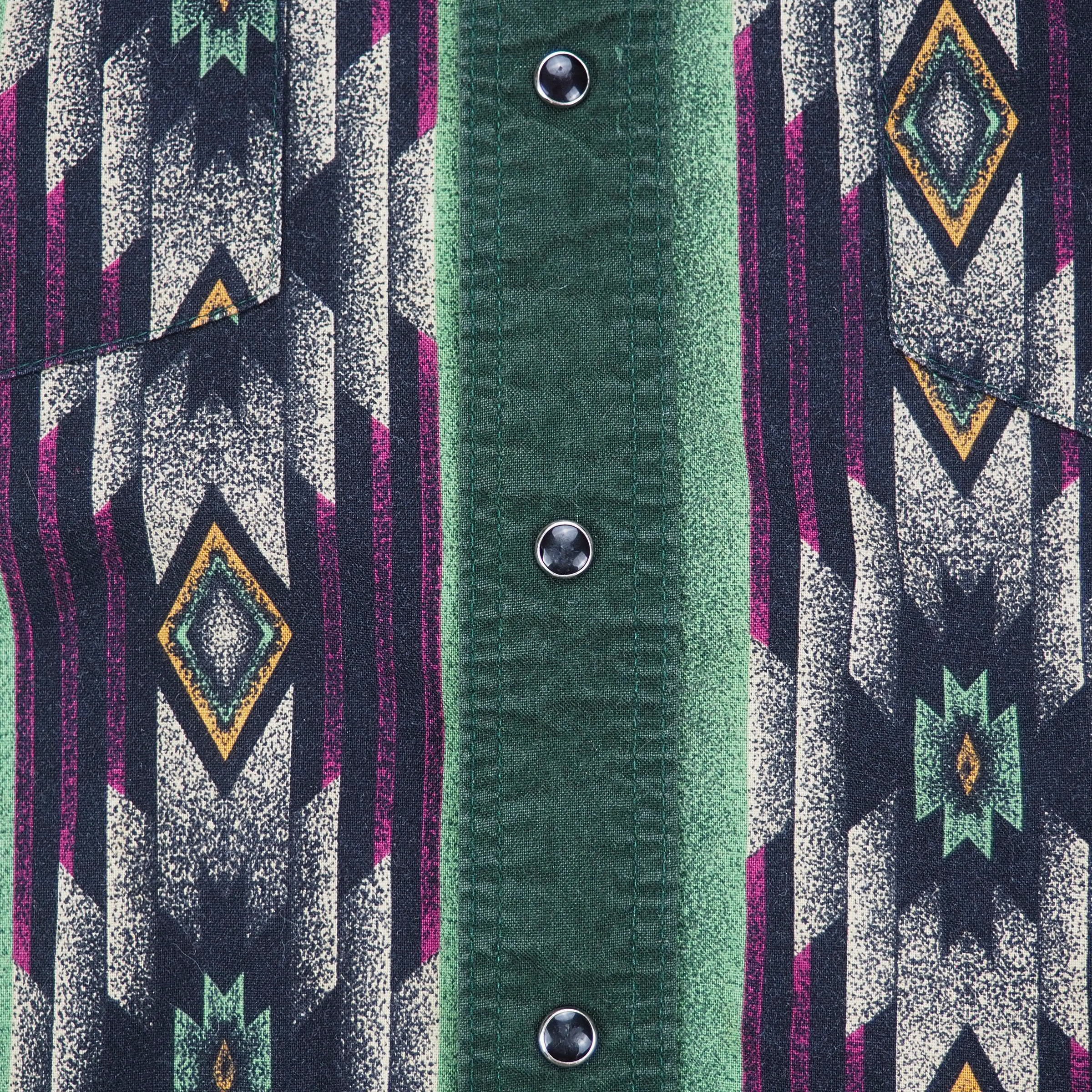 Close up of onyx press stud buttons and geometric print of a western style shirt.