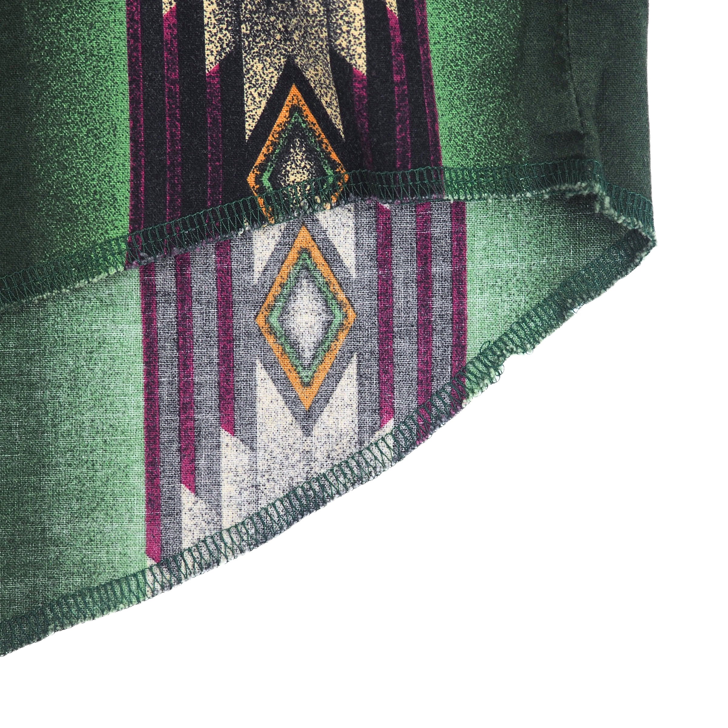 Close up of the hem and stitching details of a south western style shirt with geometric pattern.