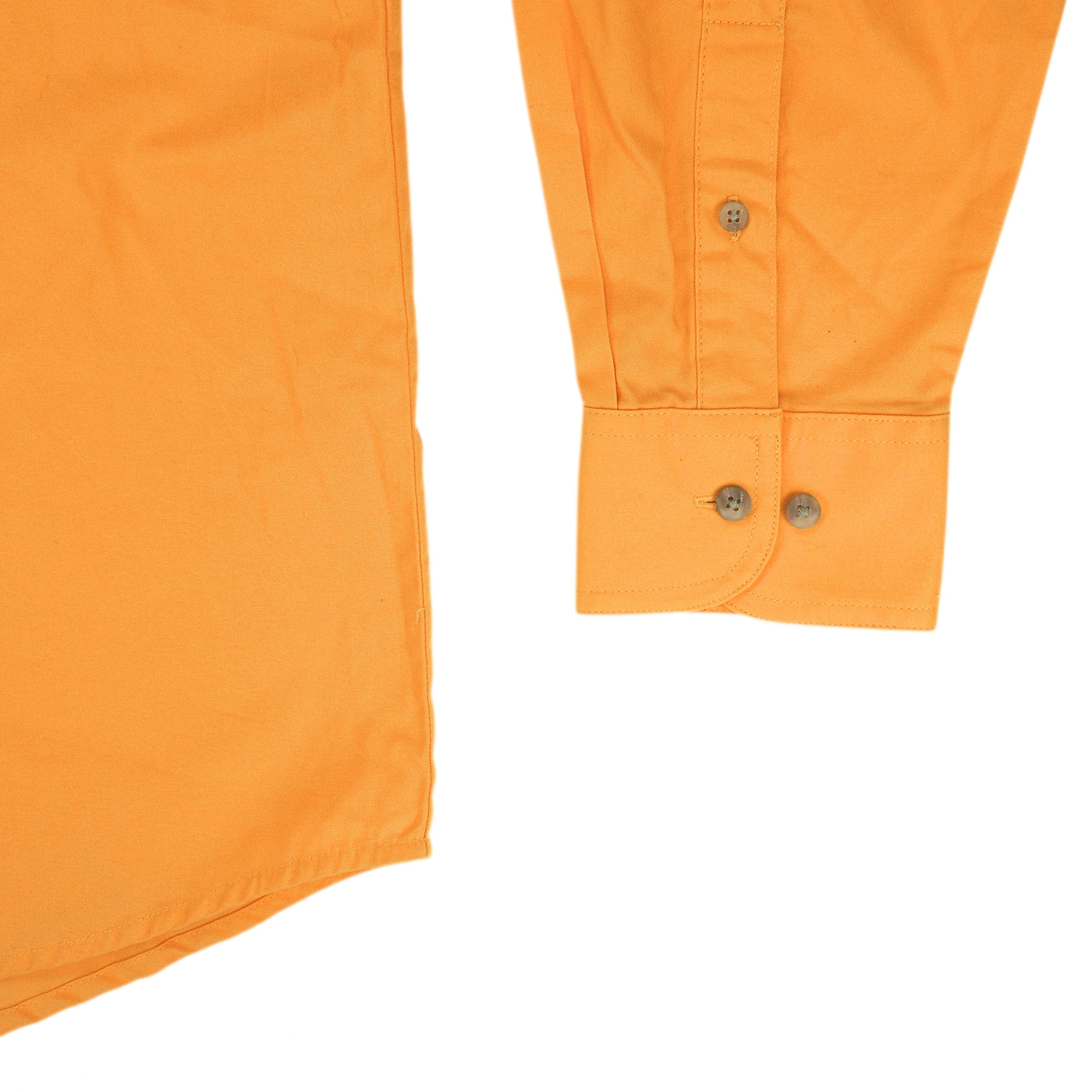 Detail of the sleeve cuff and hem of a yellow dress shirt