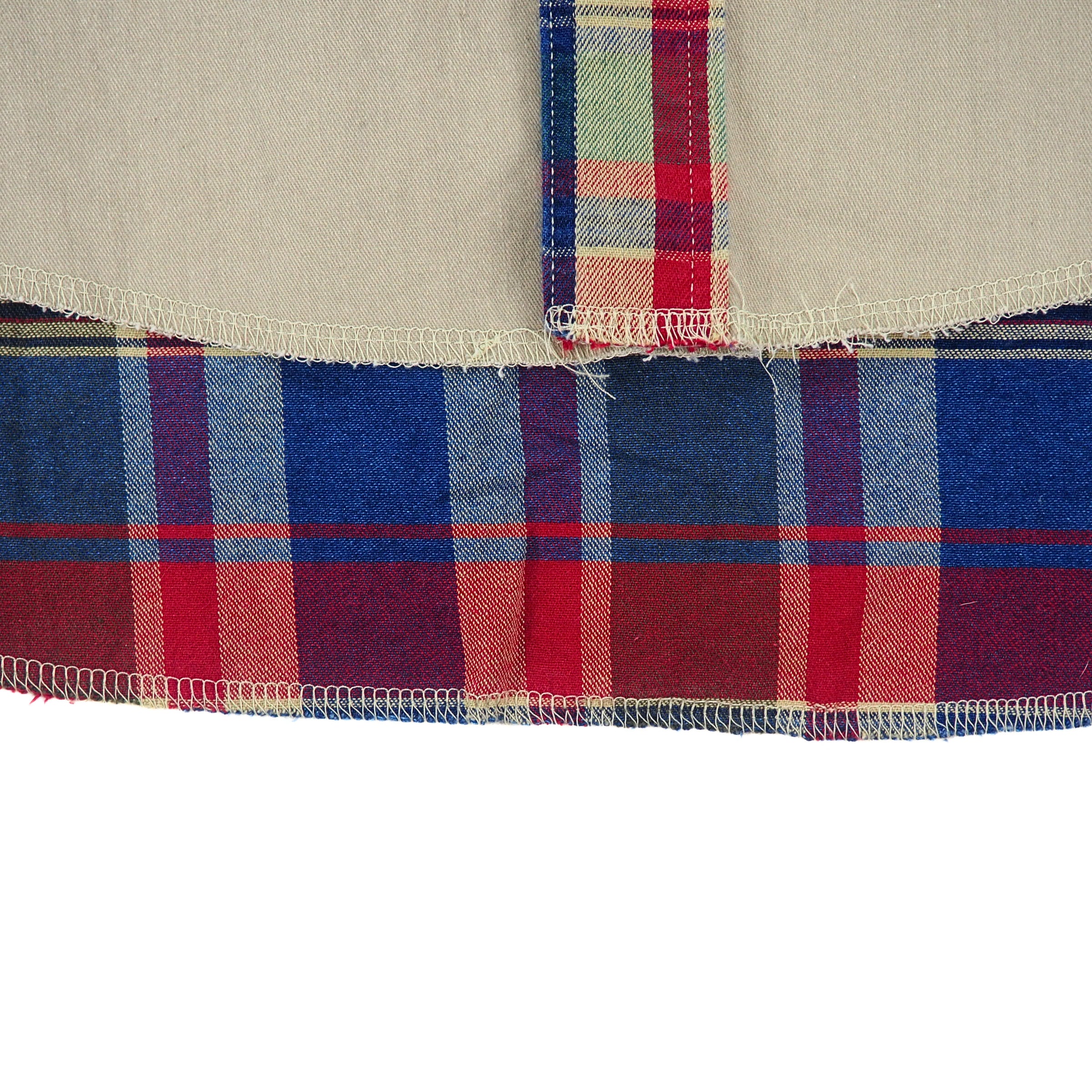 Close up of the hem of a shirt with plaid details.