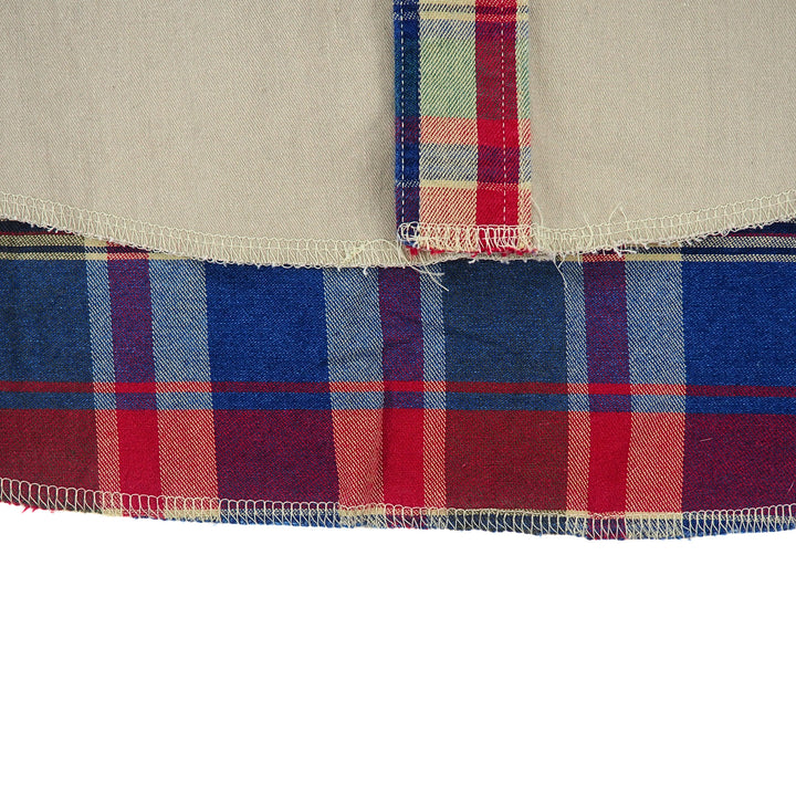 Close up of the hem of a shirt with plaid details.