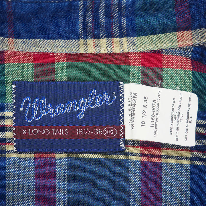 Close up of the Wrangler brand tag and care tag of a shirt with plaid details.
