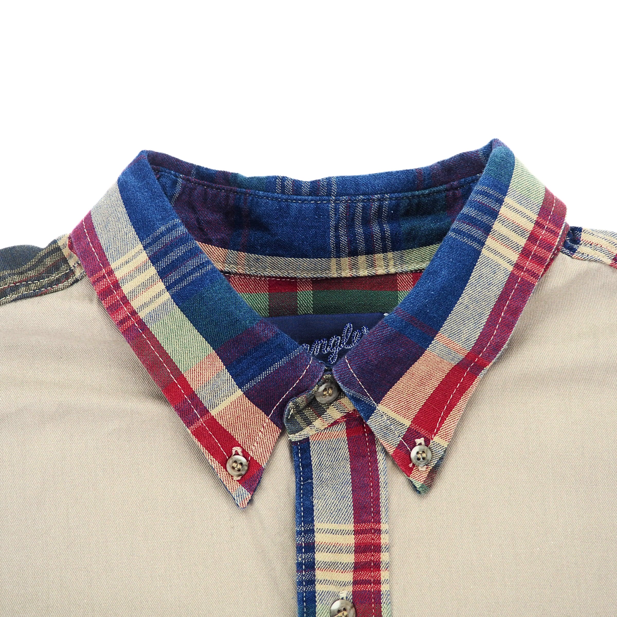 Close up of a button down collared shirt with plaid trim.