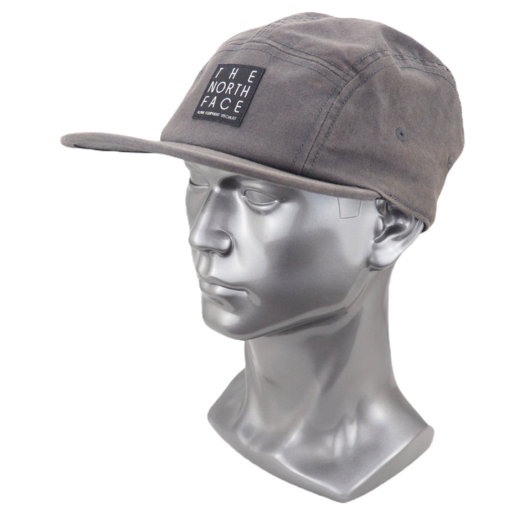 Gray cap with The North Face logo on a silver mannequin head against a white background