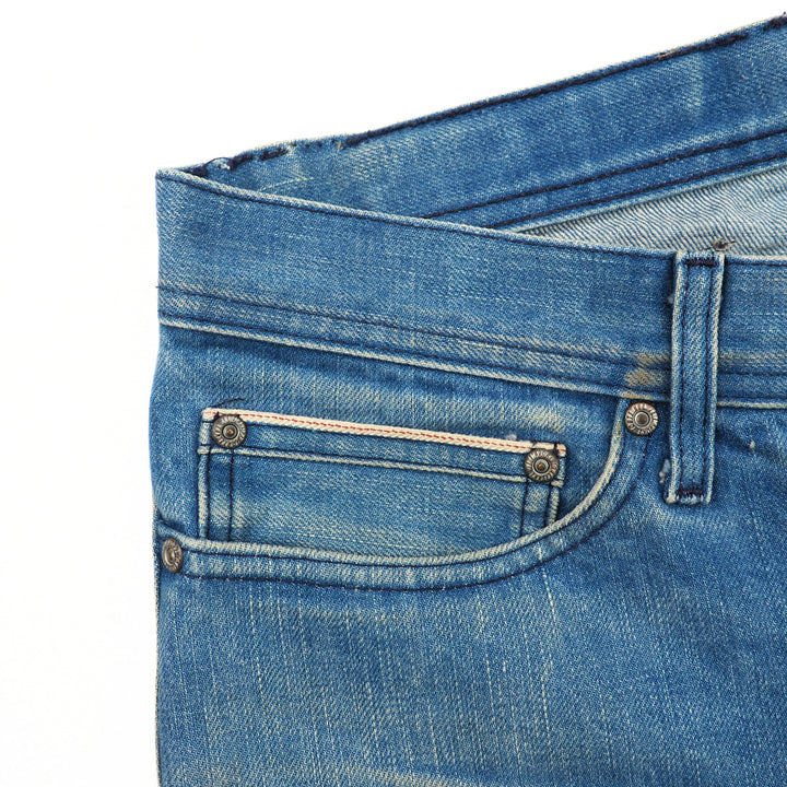 Close-up of blue jeans with a focus on the coin pocket area.