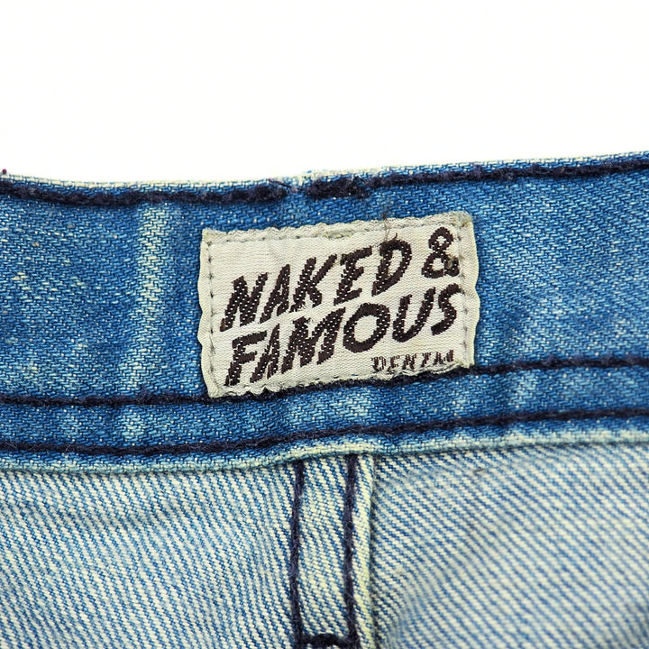 Naked & Famous denim label on a blue denim fabric background
