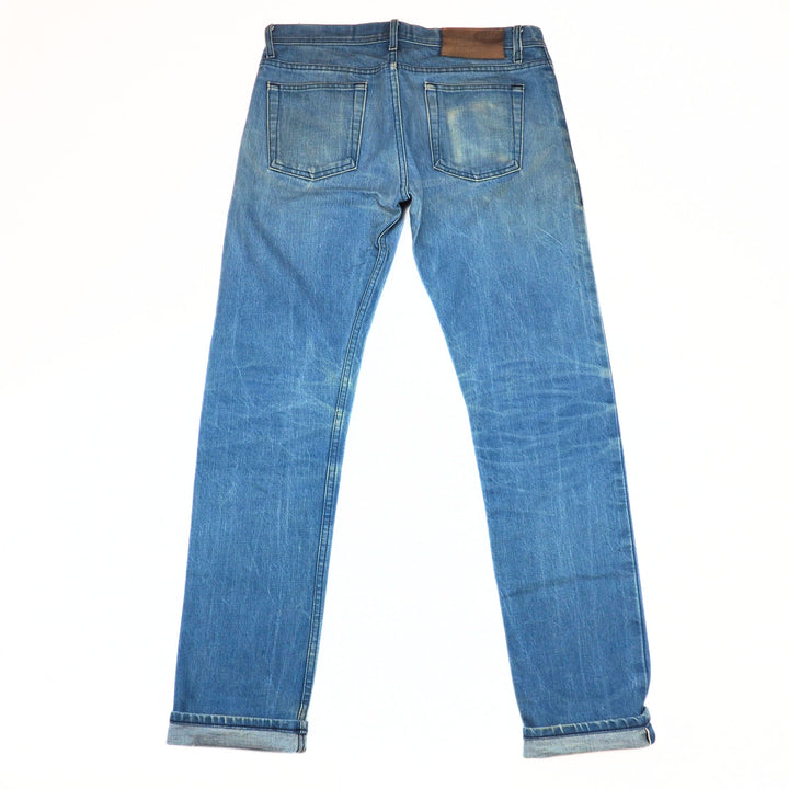 Back view of a pair of blue jeans on a white background