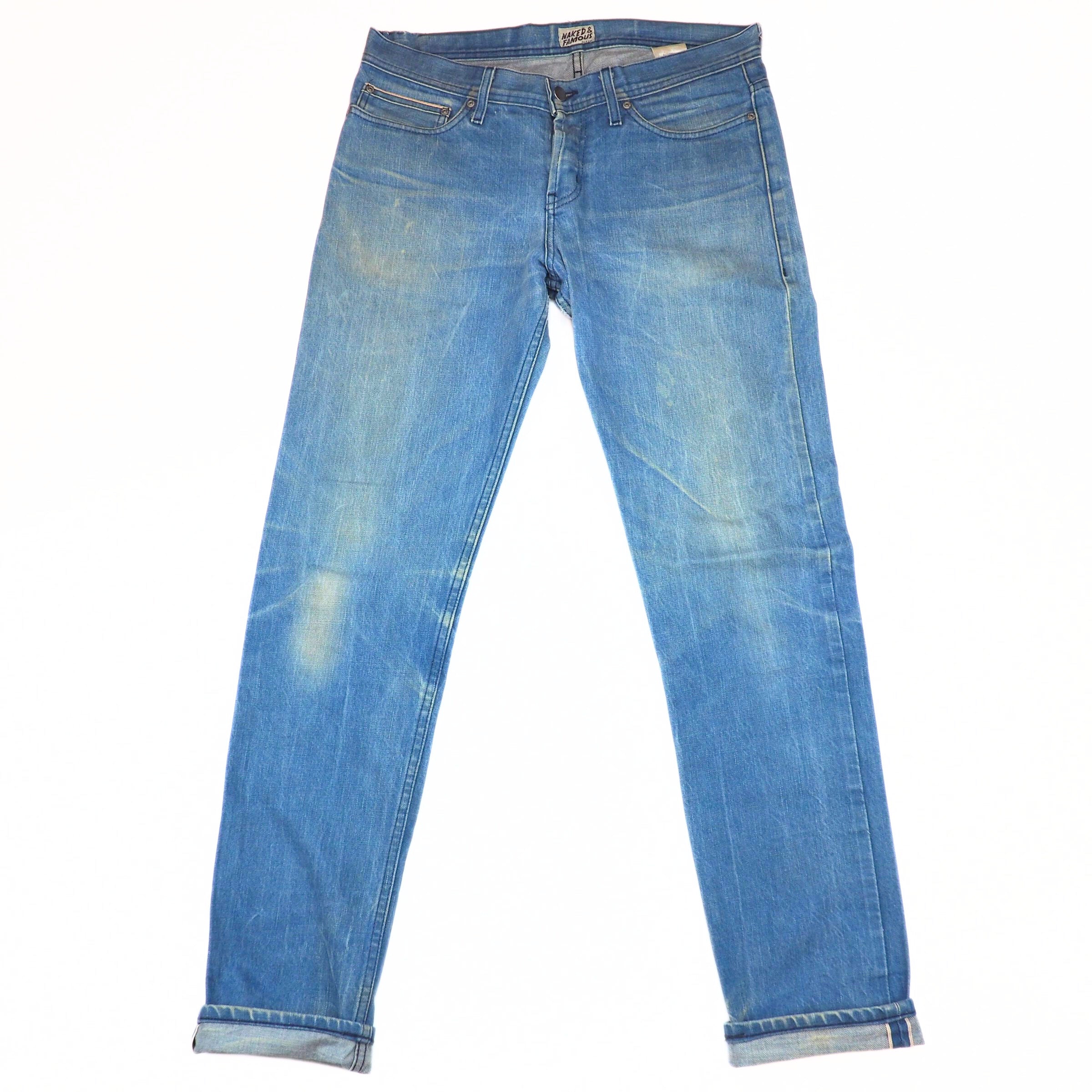 Front view of a pair of blue jeans with turned up cuffs on a white background