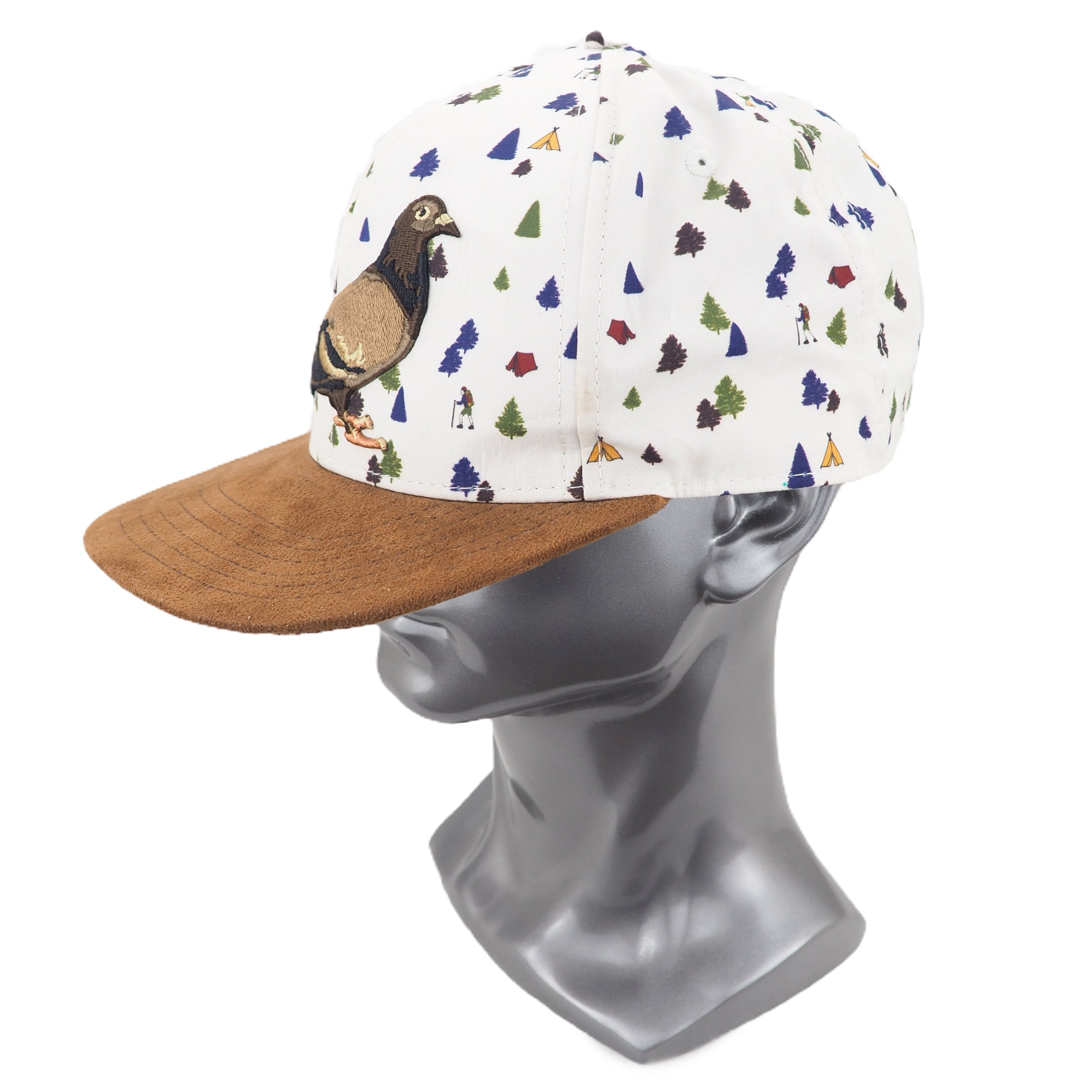 Cap with colorful pattern and brown brim on a mannequin head against a white background