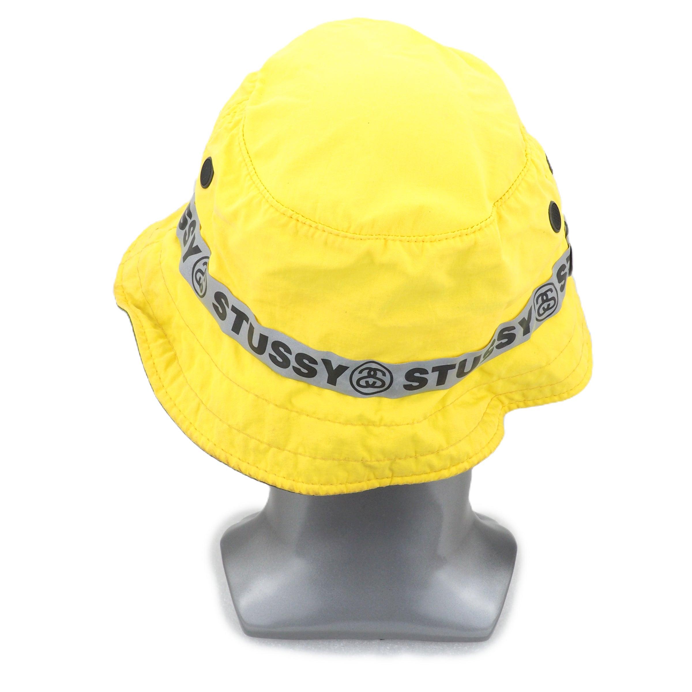 Yellow bucket hat with a gray 'Stussy' band on a mannequin head against a white background