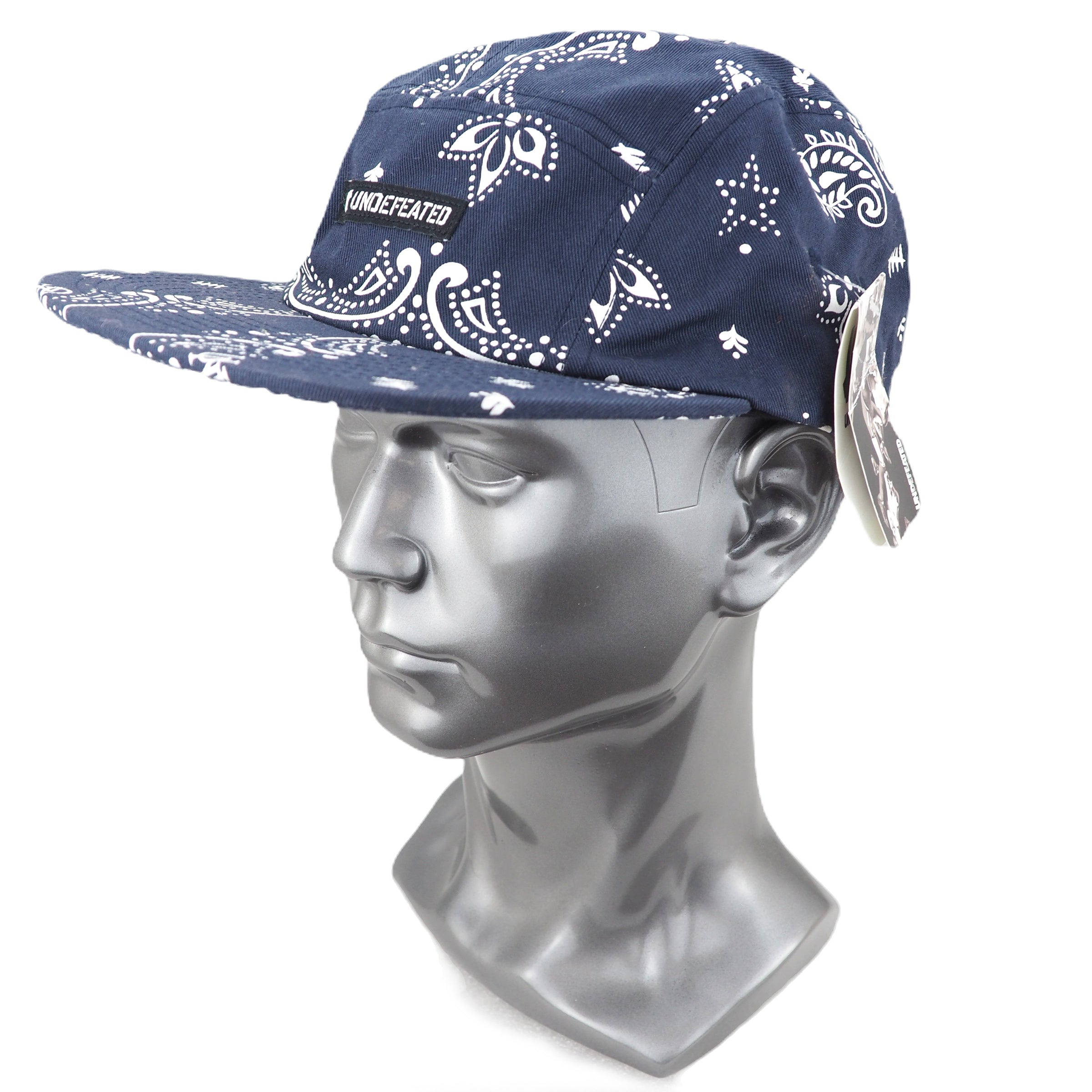 Blue bandana-patterned cap on a mannequin head with 'Undefeated' branding.