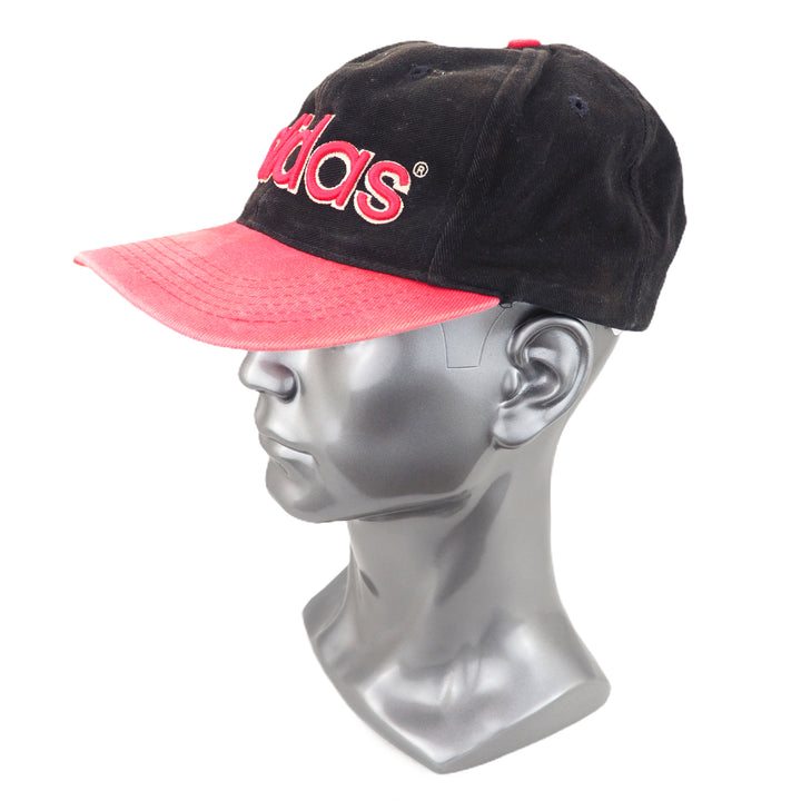 Faded black and red Adidas cap on a mannequin head against a white background