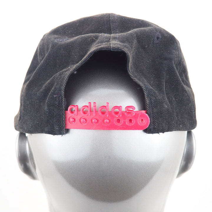 Black cap with pink Adidas logo on a mannequin head against a white background