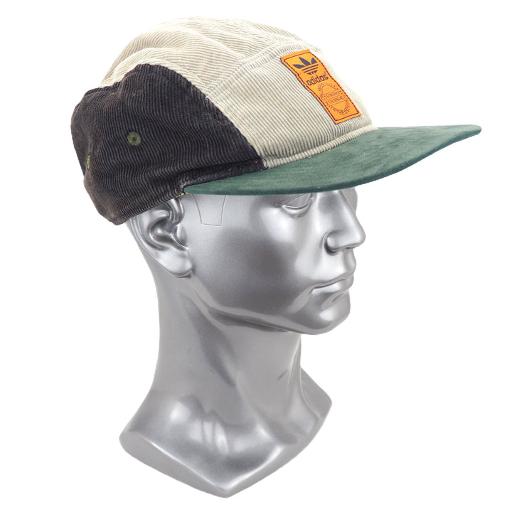 Three-tone cap with orange label on a mannequin head against a white background