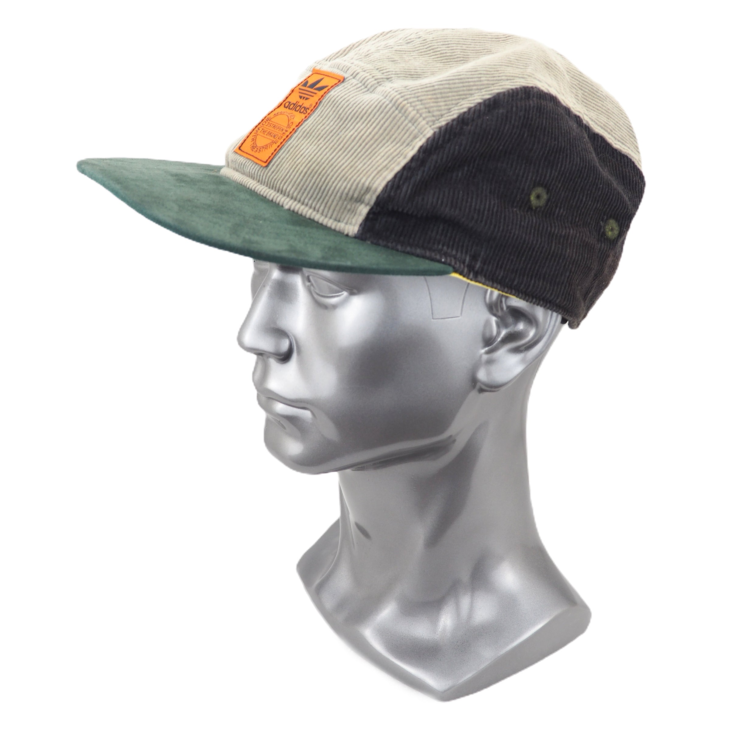 Multicolored corduroy cap on a mannequin head against a white background