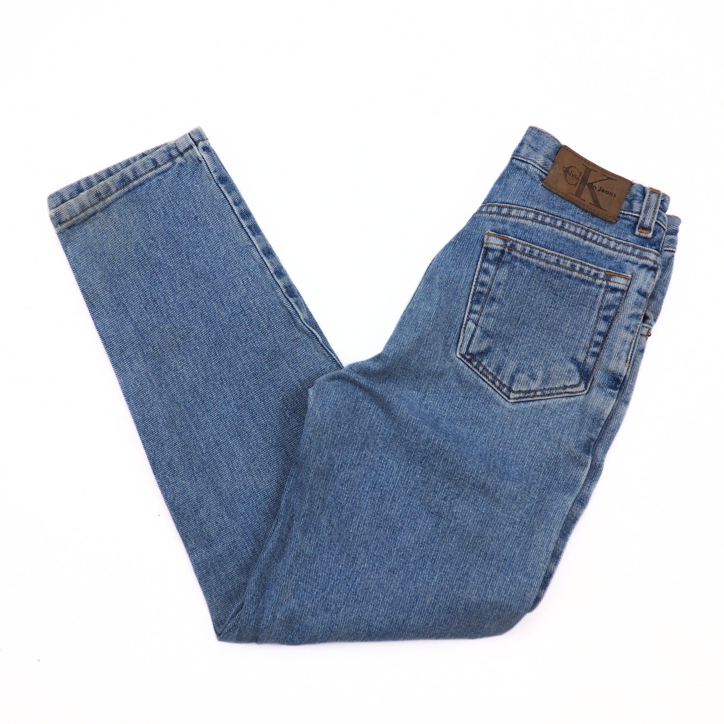 Folded blue jeans with a brand label on a white background