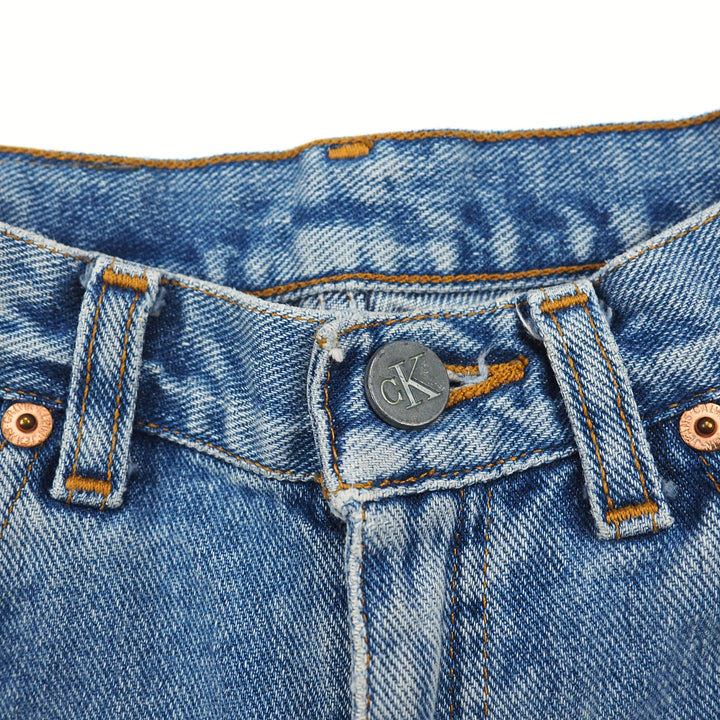 Close-up of blue denim jeans with a brand logo on the button area.