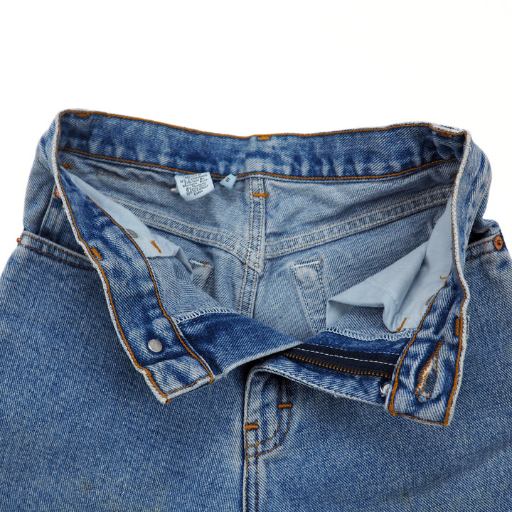 Unzipped pair of blue jeans with a visible inner care label on a white background