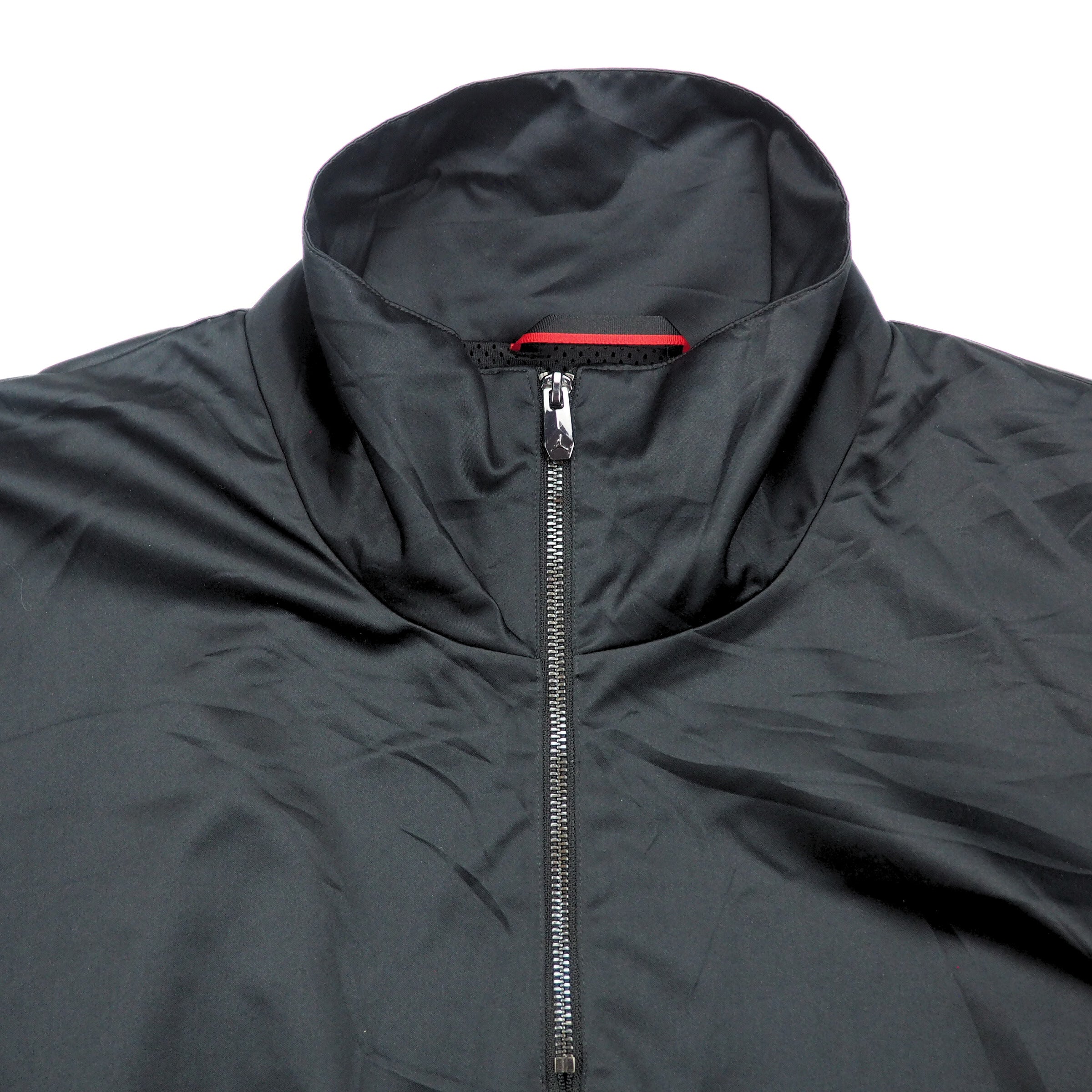 Detail of the front collar of a black jacket with a zipper on a white background