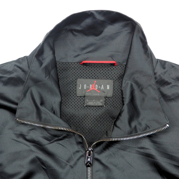 Black jacket with a Air Jordan brand logo on the inside of the collar against a white background