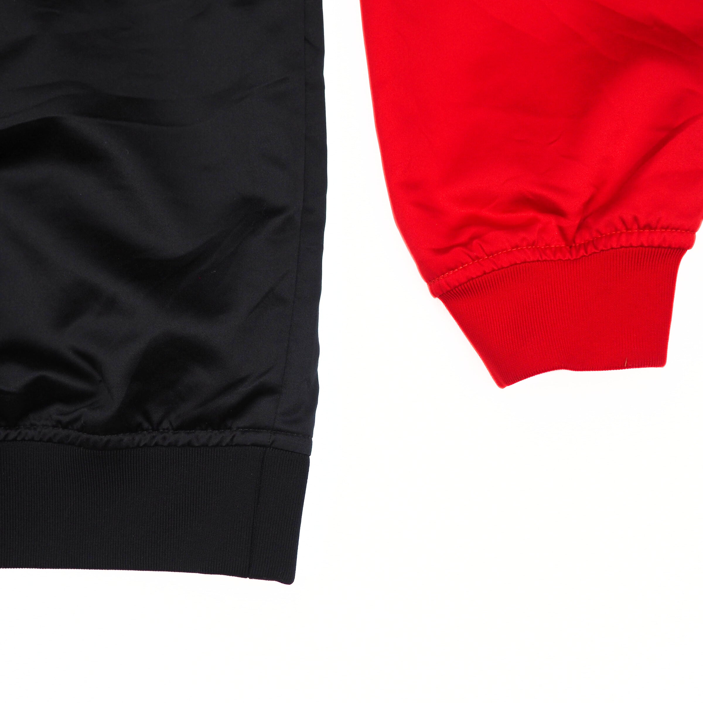 Close-up of black and red jacket body and sleeve on a white background