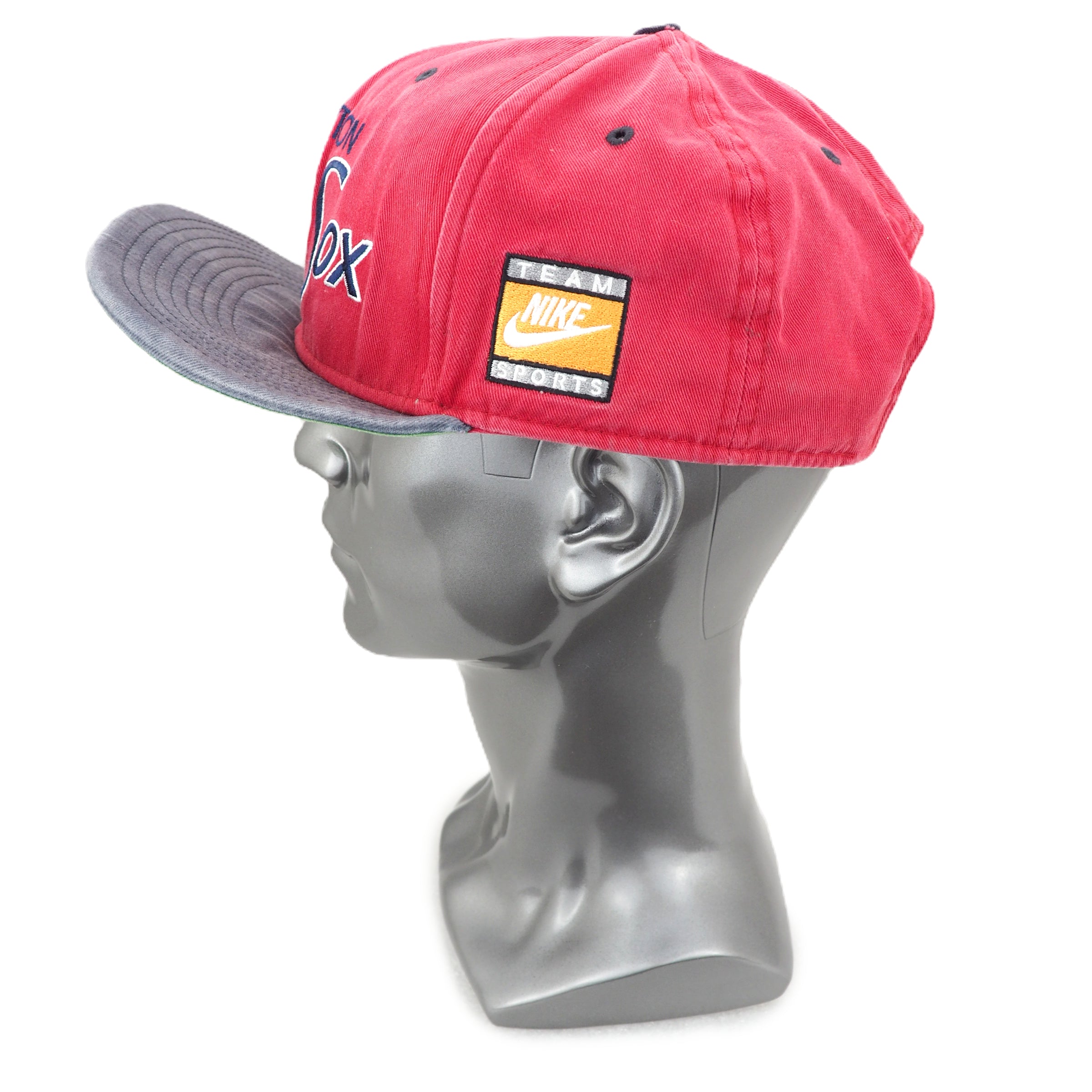 Red and gray cap with Nike logo on a mannequin head against a white background