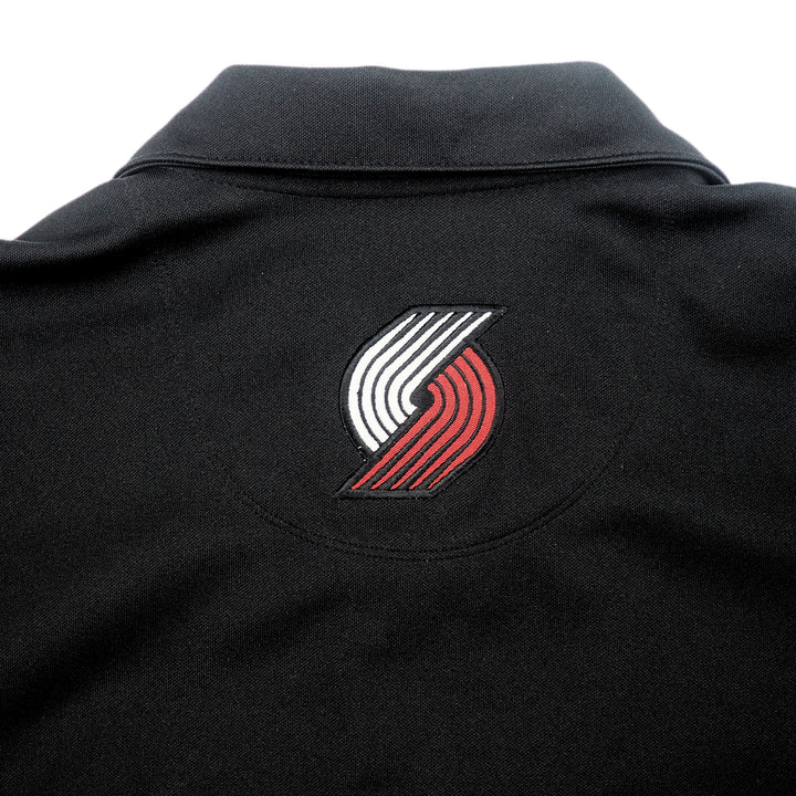 Detail of back collar of a vintage black Nike Team Sports Portland Trailblaizers jacket with a logo against a white background