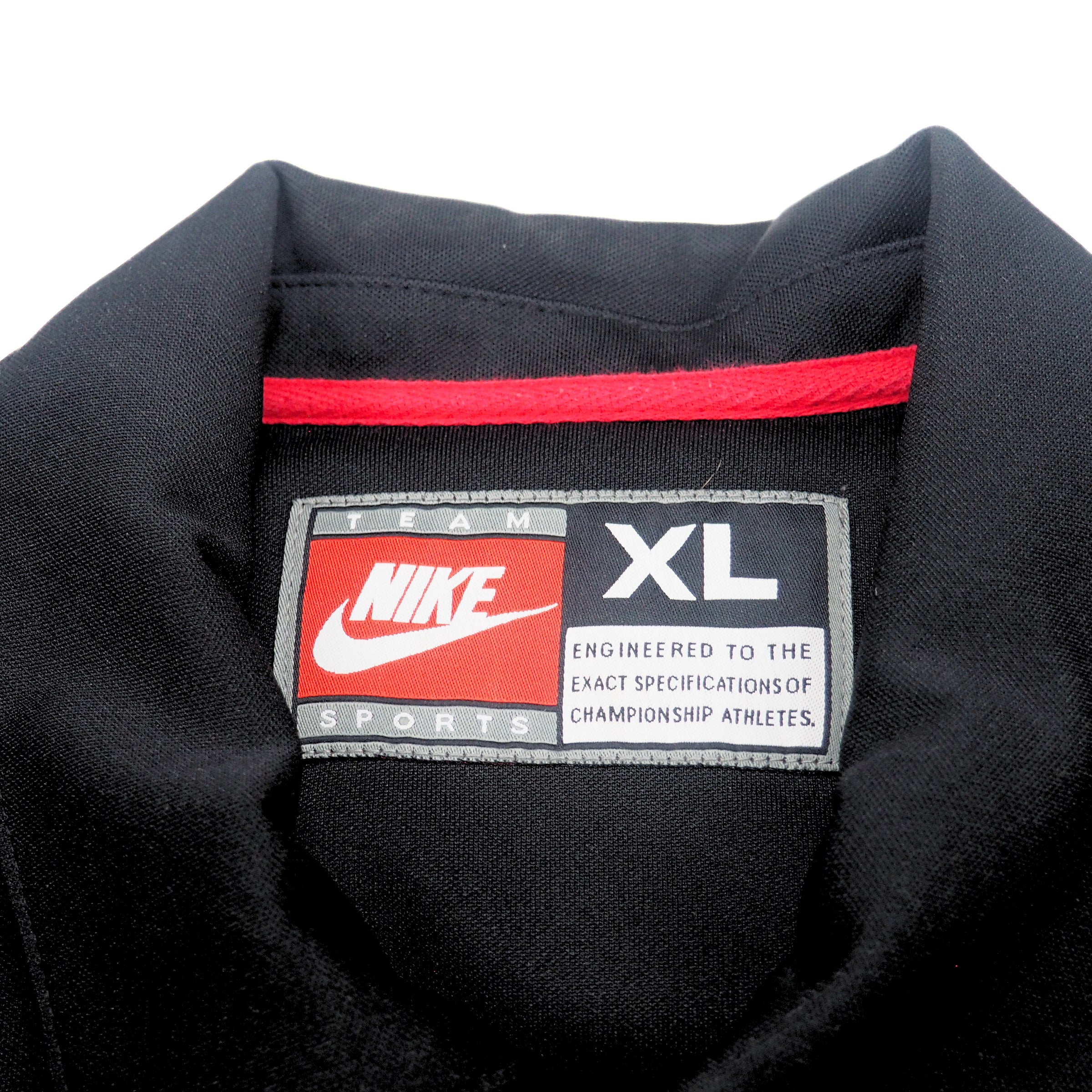 Inside collar detail of a black basketball warm up jacket with a Nike Team Sports label on a white background