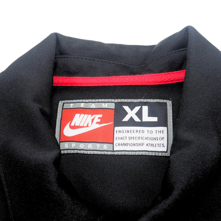 Inside collar detail of a black basketball warm up jacket with a Nike Team Sports label on a white background