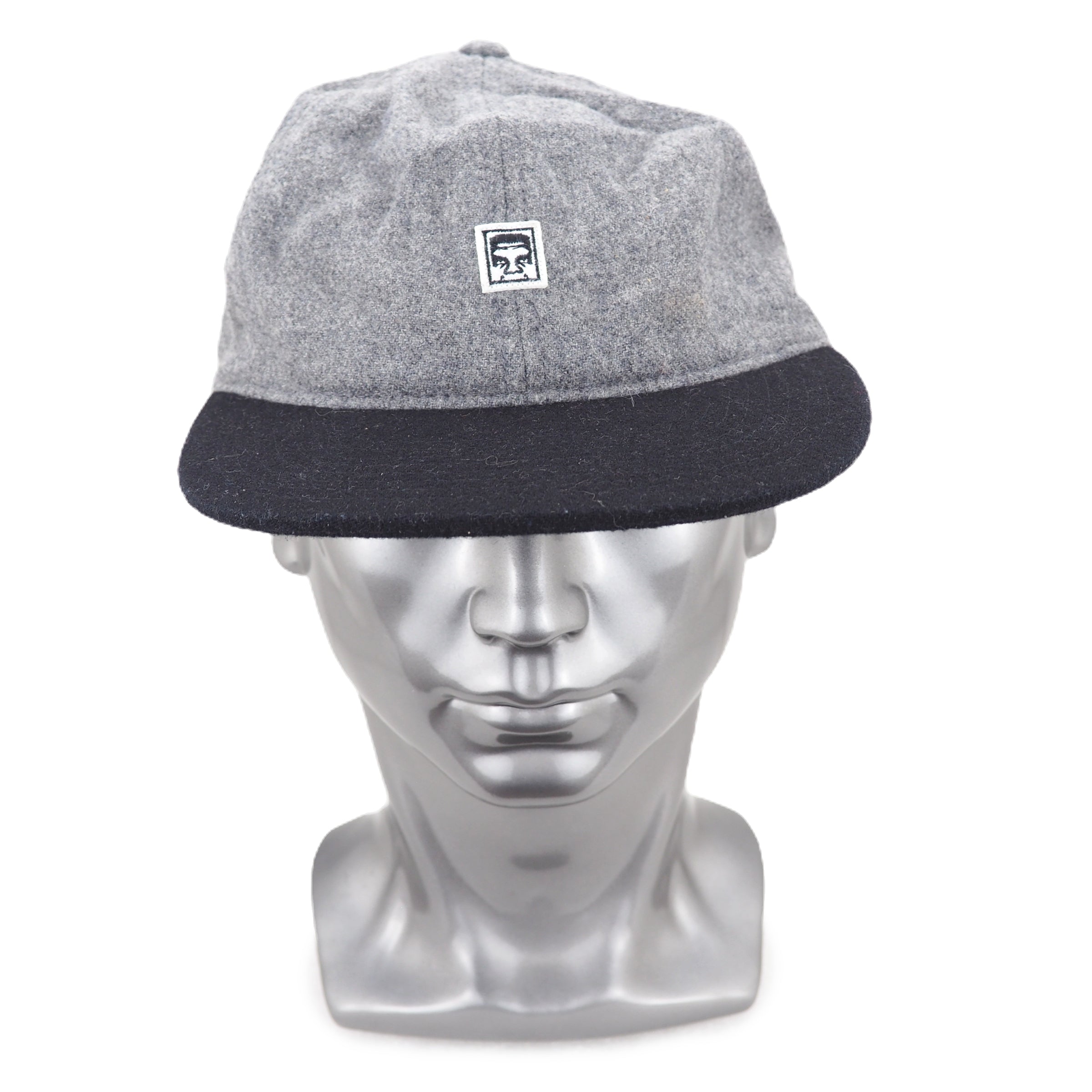 Gray and black cap on a silver mannequin head with a white background