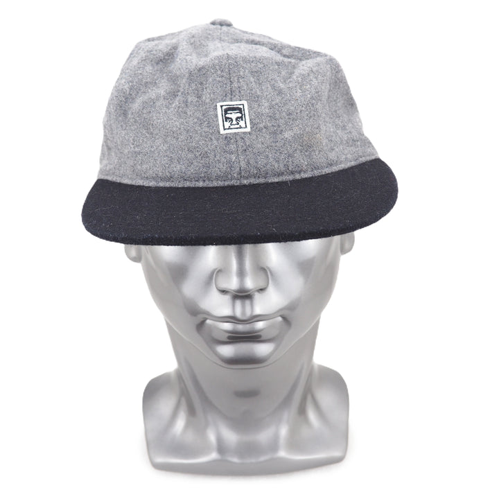 Gray and black cap on a silver mannequin head with a white background